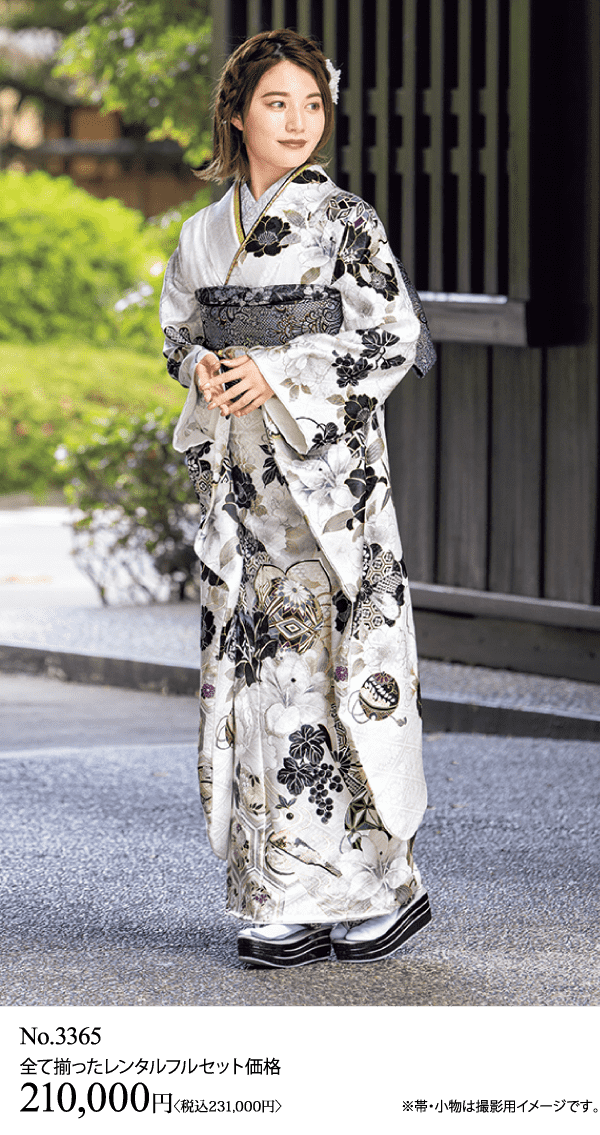 花柄の着物を着た人が伝統的な建物の外に立っています。.