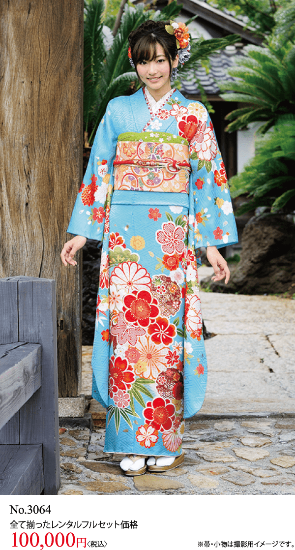 色鮮やかな花柄の着物を着た女性が屋外に立って微笑んでいます。彼女は花の髪飾りをつけています。.