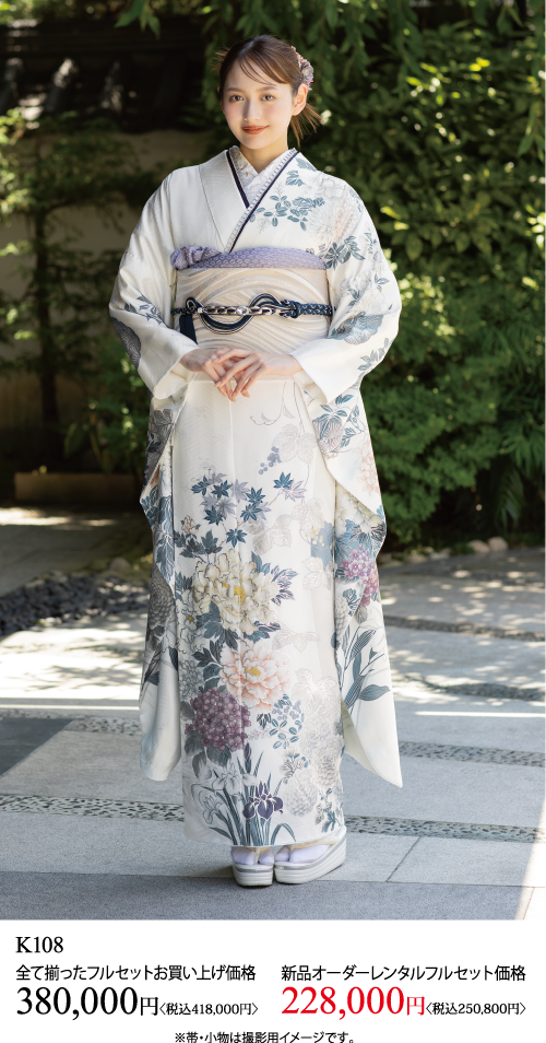 青とグレーの模様が入った白い花柄の着物を着て、濃い色の帯を締めた女性が屋外に立っている。両手を前で組み、柔らかく微笑んでいる。画像の下に日本語のテキストと着物の価格が表示されている。.