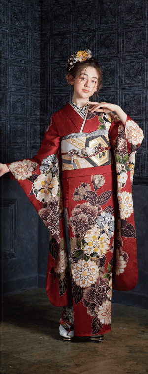 精巧な帯と髪飾りをつけた伝統的な花柄の着物を着てポーズをとる女性。